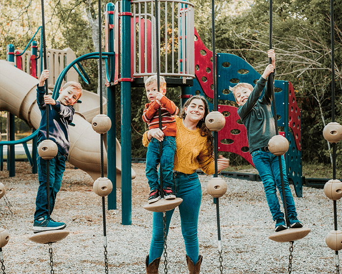 au pair with host children playing on playground