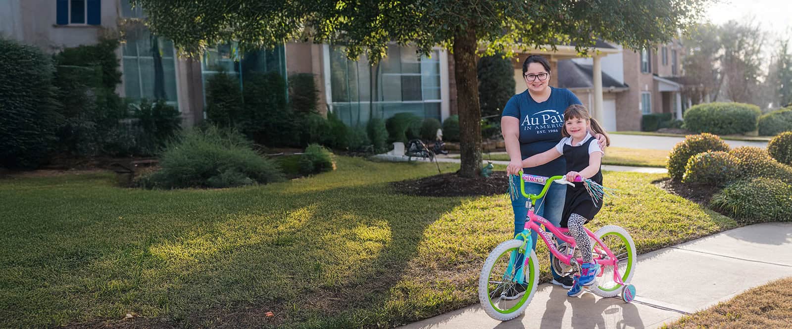 au pair with child on bike.