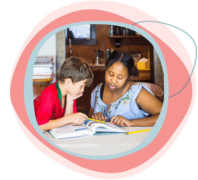 Au pair helping host child with homework.